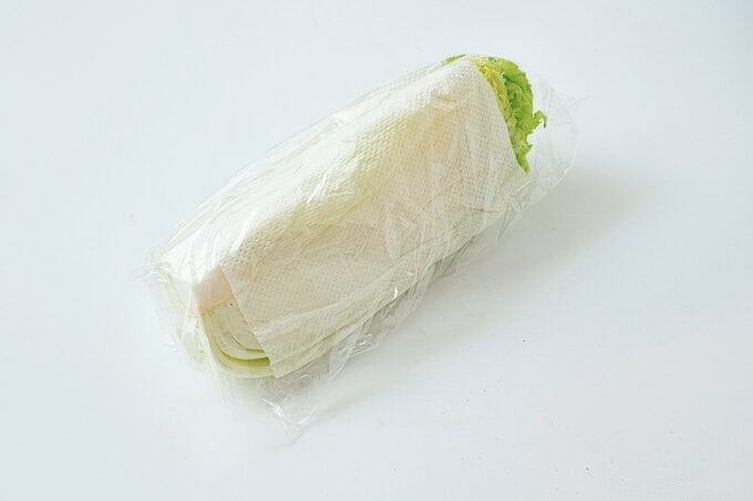 切り口にペーパータオルをかぶせてポリ袋に入れられた白菜