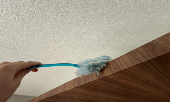 折り上げ部分をハンディモップで掃除している様子