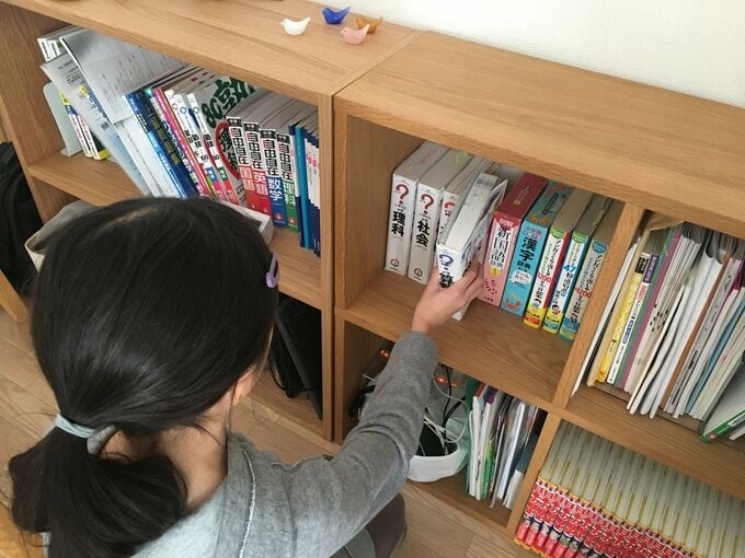女の子が参考書をとるところ