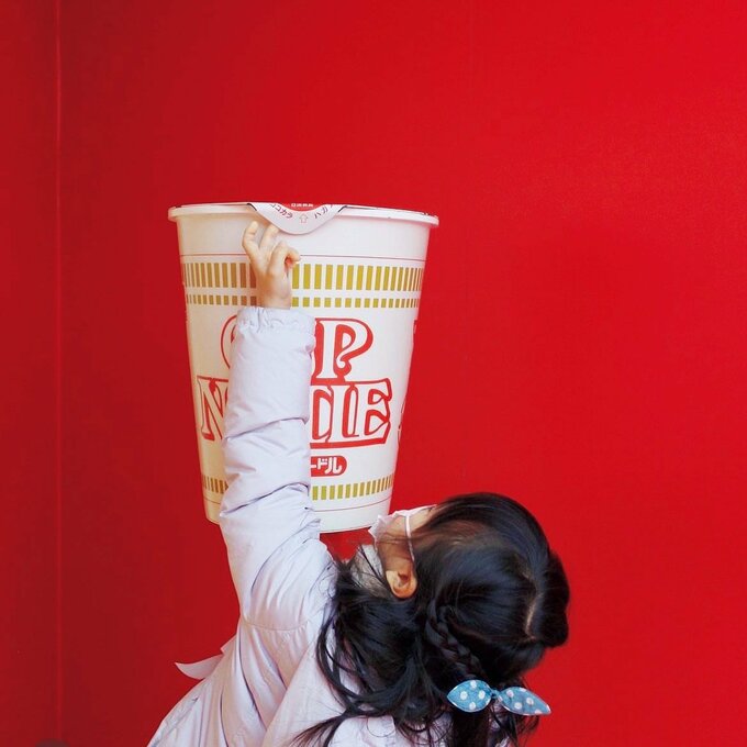 大きなカップヌードルを触る女の子