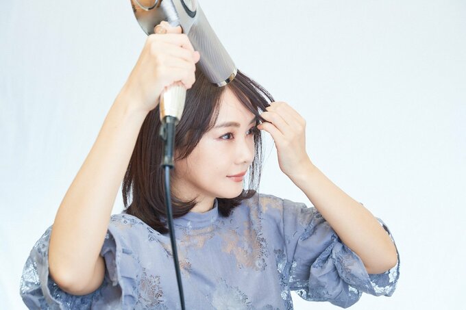 前髪を乾かす女性