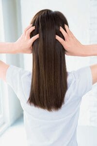 後頭部に指をあてた後ろ姿