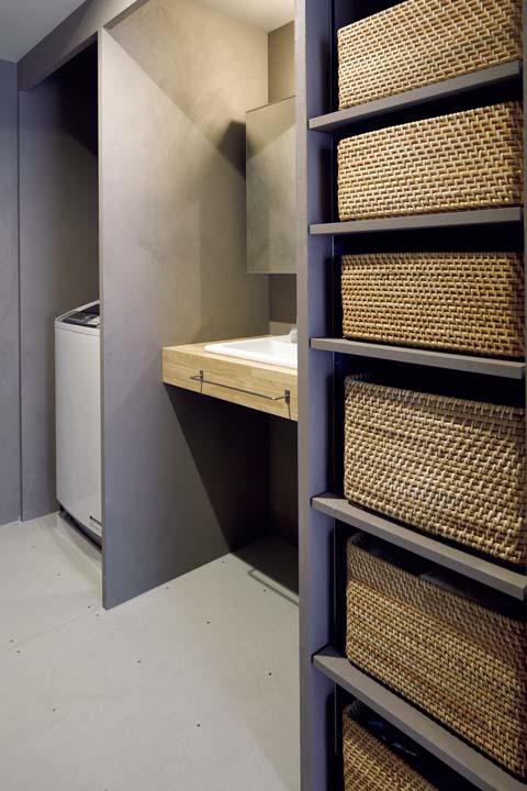 壁でさりげなく洗濯機を隠しているシンプルな洗面室