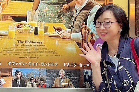 ポスターの前に立つ川上麻衣子さん