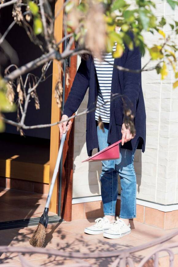 玄関先を掃く様子