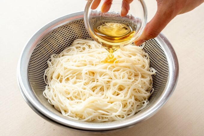 そうめんにゴマ油を混ぜている様子