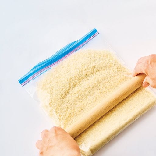 パン粉を入れた保存袋の上でめん棒を転がして均一になるまで砕く。油を吸う量が減り、さっくりと仕上がる