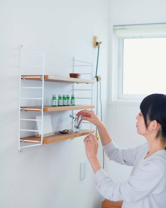 棚にものを置く女性