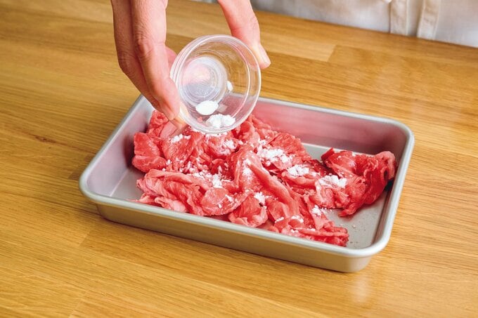 牛肉に片栗粉をふる様子