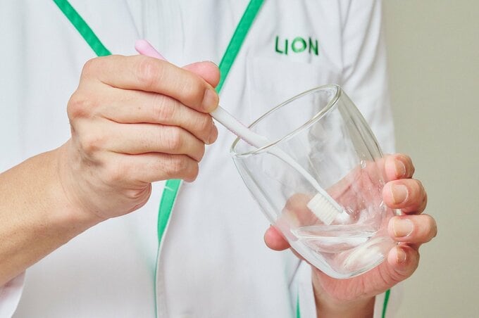 ハブラシを水につけている