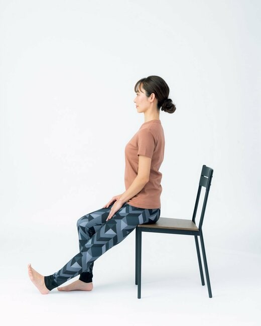 椅子に腰かける人