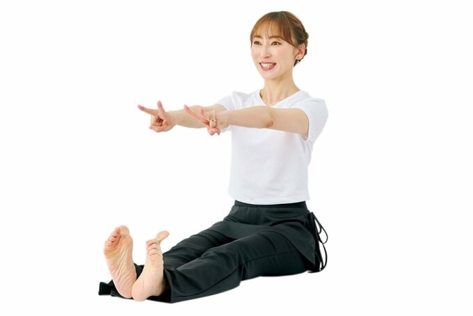 腕と足を伸ばして座り笑顔の女性