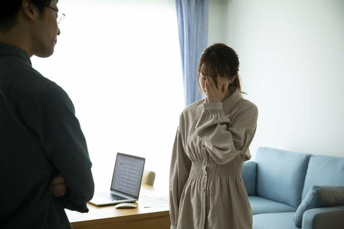 手で顔を押さえる女性