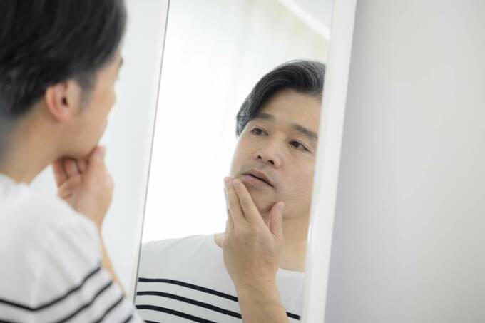鏡を見る男性