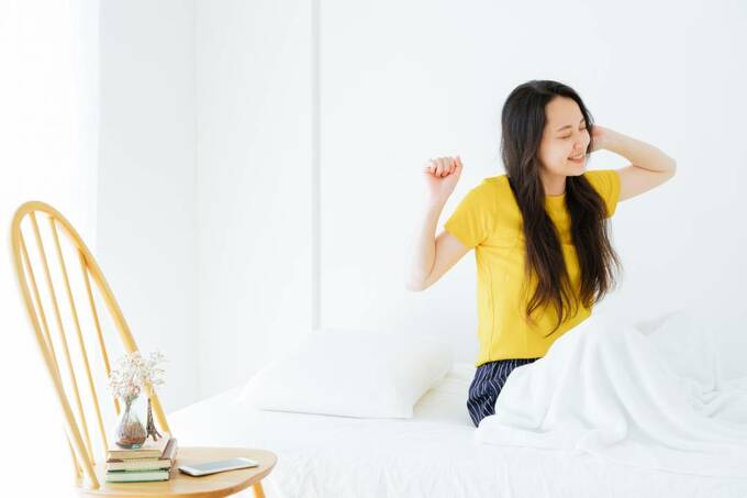 ベッドで起きる女性