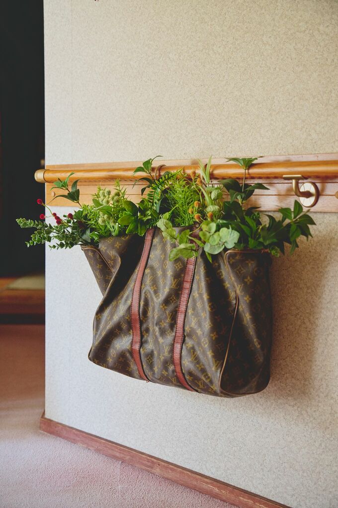 . 廊下の手すりに下がっているのは 古いルイ・ヴィトンのバッグ。 100 円ショップで買ったフェイクグリー ンを飾っています。