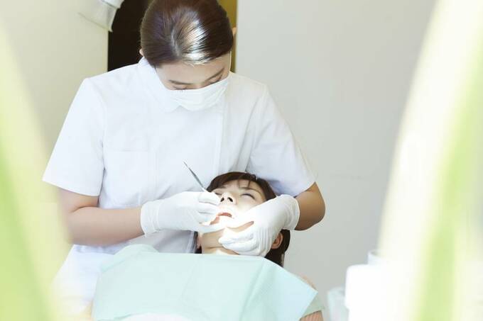 歯医者に歯を見られている様子