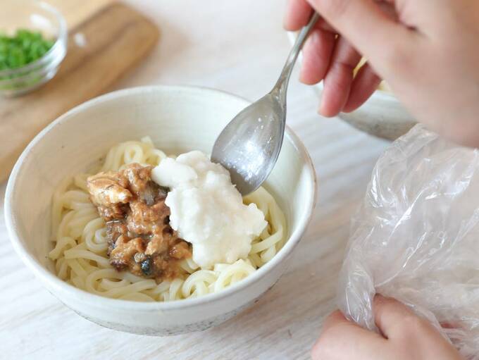 うどんにとろろとサバを入れる
