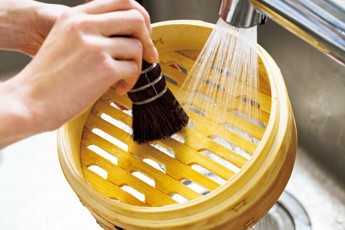 せいろをササラと流水で洗っている手元