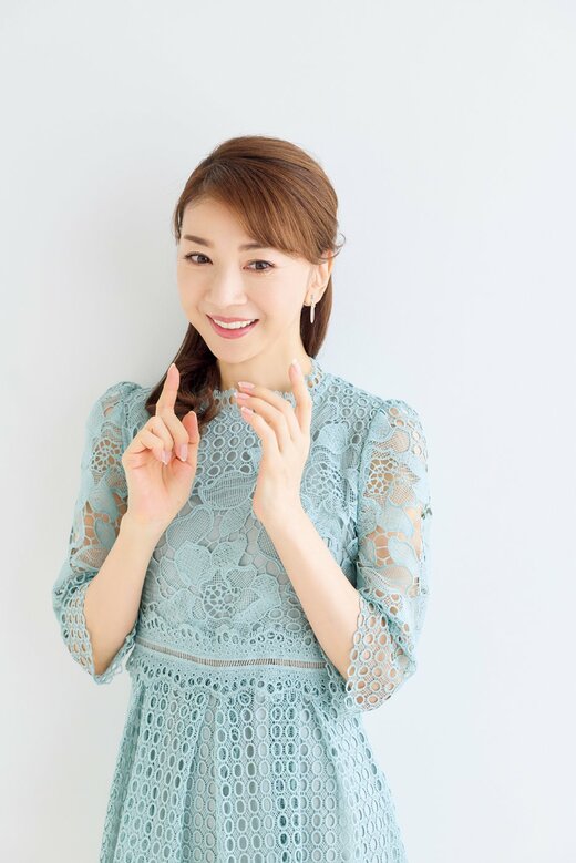 胸の前に両手を掲げて立つ女性