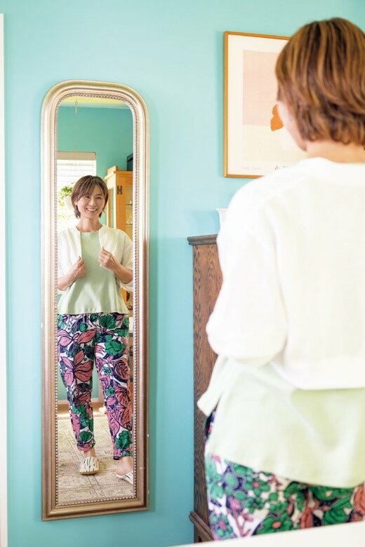 手づくりの服を着ている自分を鏡で見てほほ笑むTさん
