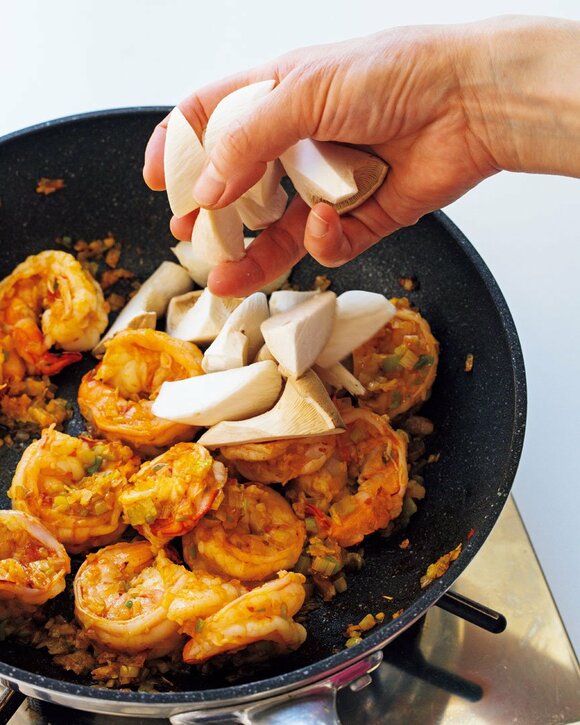 エビが入ったフライパンにエリンギを入れる様子