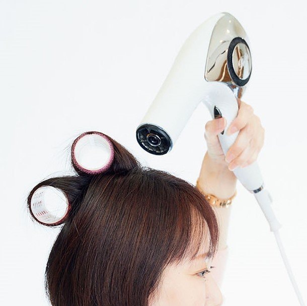 マジックカーラーを巻いた髪にドライヤーを