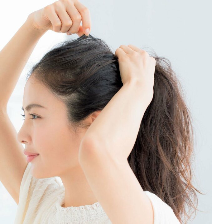 横顔女性右手で髪をつまむ