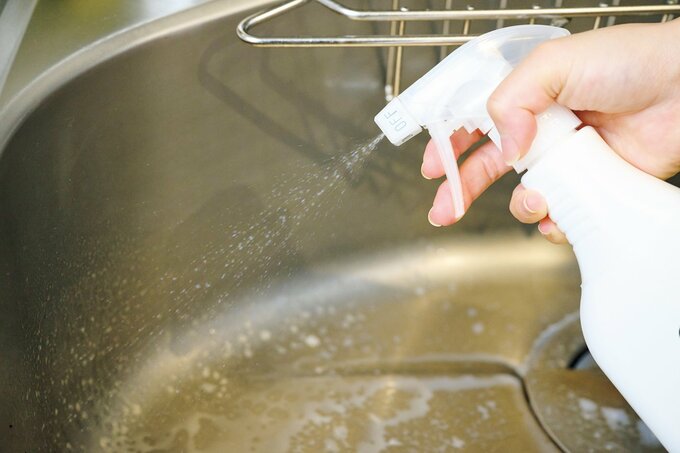 キッチンのシンクにスプレーを吹きかける様子