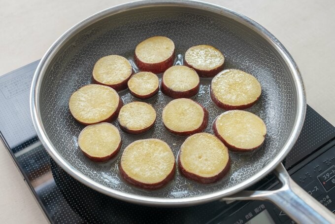 フライパンにさつまいもを並べて焼いている