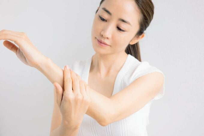 左腕を触る女性