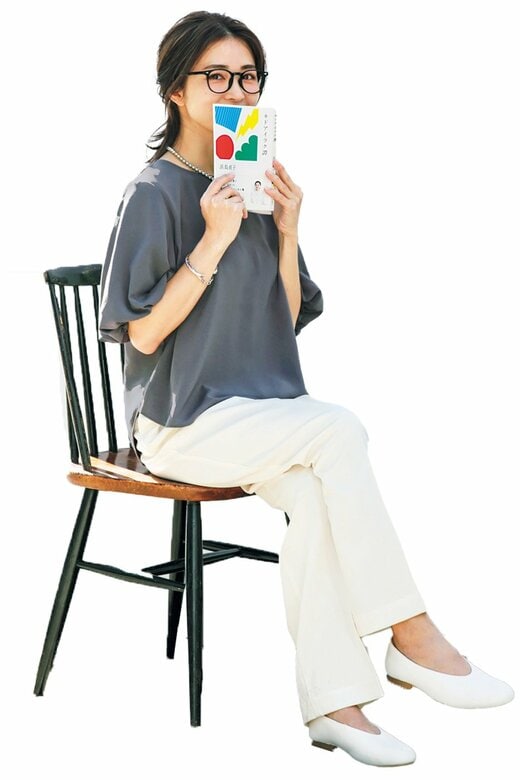 本を口元に当てる女性