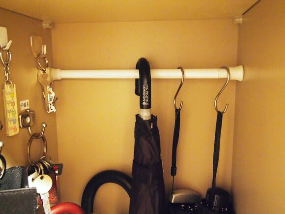 つっぱり棒＋フックで傘を収納している様子