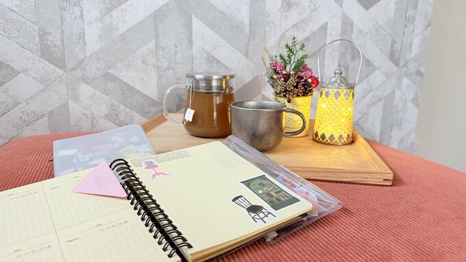 机にノートなどコップが置かれている様子