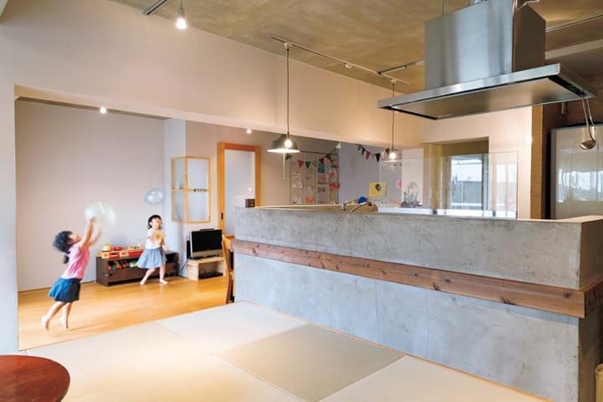 モルタル仕上げのキッチン腰壁のあるLDK