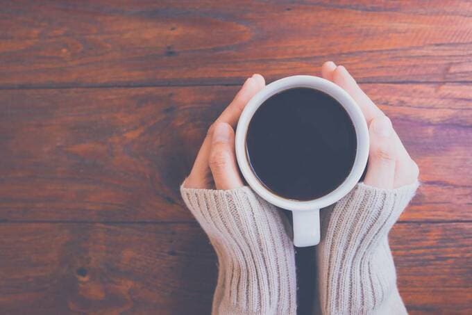 コーヒーカップに両手を添えている様子