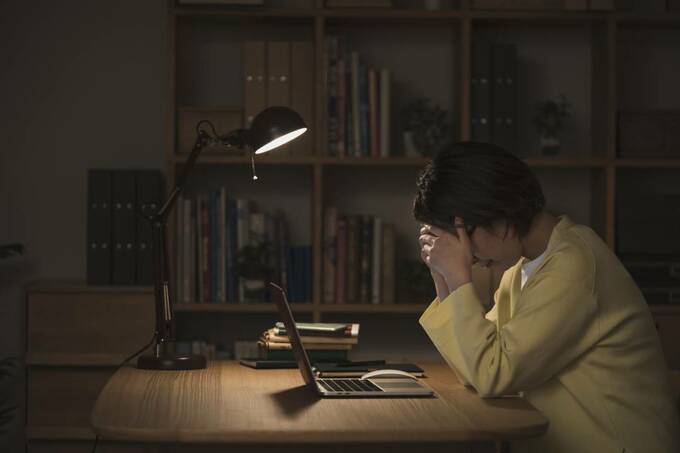 パソコンの前で悩む女性