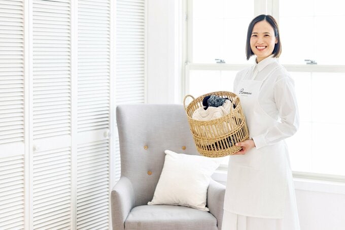 洗濯かごを持つ笑顔の女性