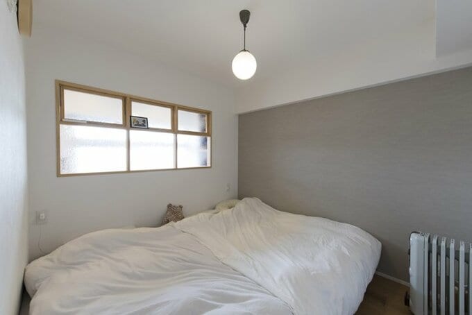 隣接する玄関土間との間に室内窓を設けた寝室