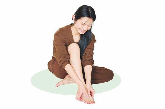 足の甲のツボを押す女性