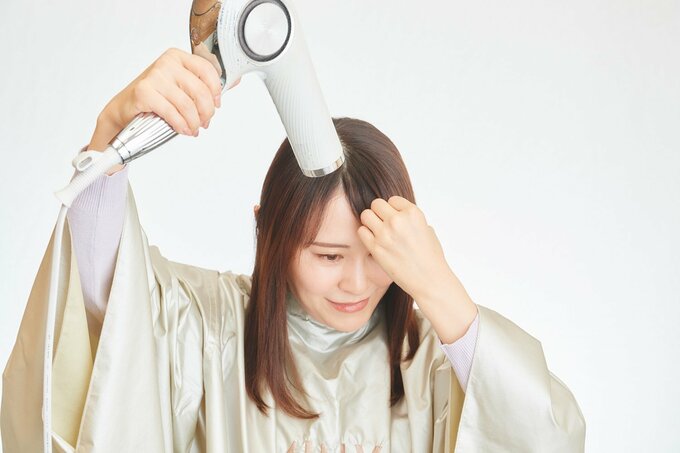 前髪のクセをとる女性