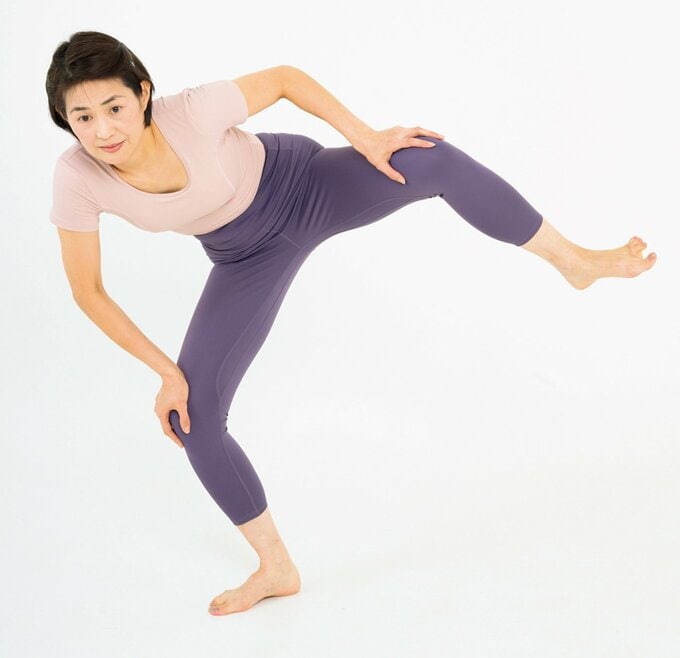 右足に体重をのせて左足を上げる女性