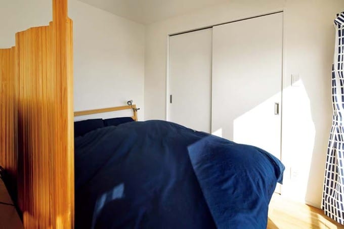 パーテーションで区切っただけのコンパクトな寝室