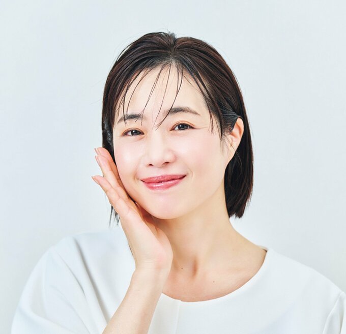 頬に手を当ててほほ笑む女性