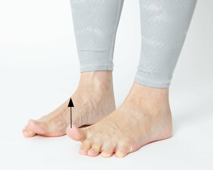 床に立ったまま親指だけ上にあげている両足