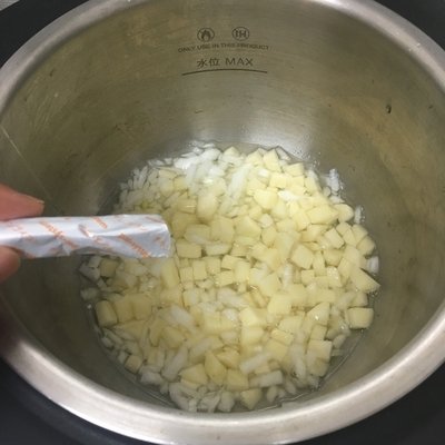 容器に入ったジャガイモにコンソメを入れる