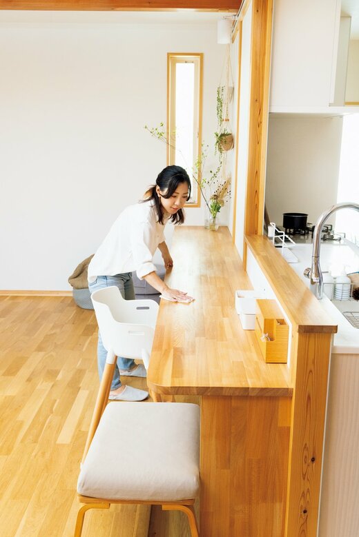 ほとんどものが置かれていない机を拭く女性