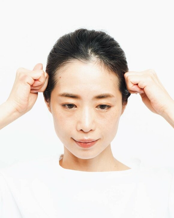 こぶしで生え際や眉の上を押す