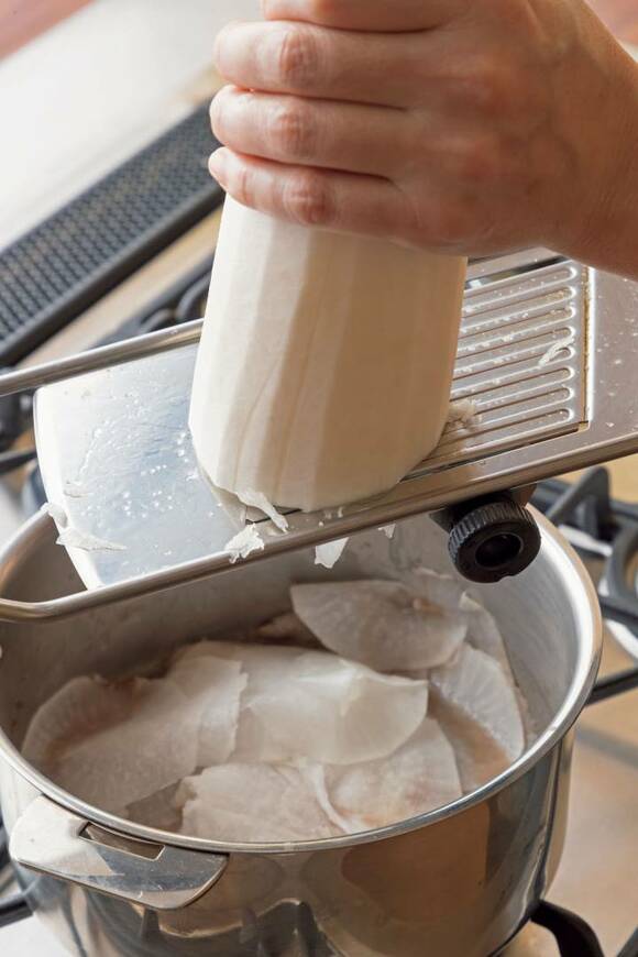 スライサーで大根を薄切りにする様子