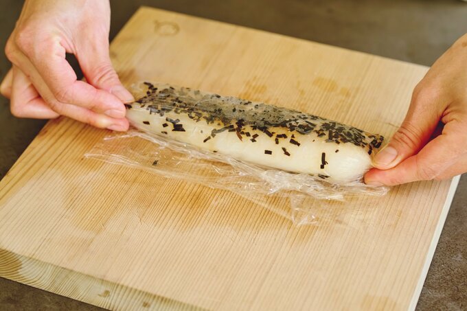 塩昆布をまぶした鯛をラップで包む様子